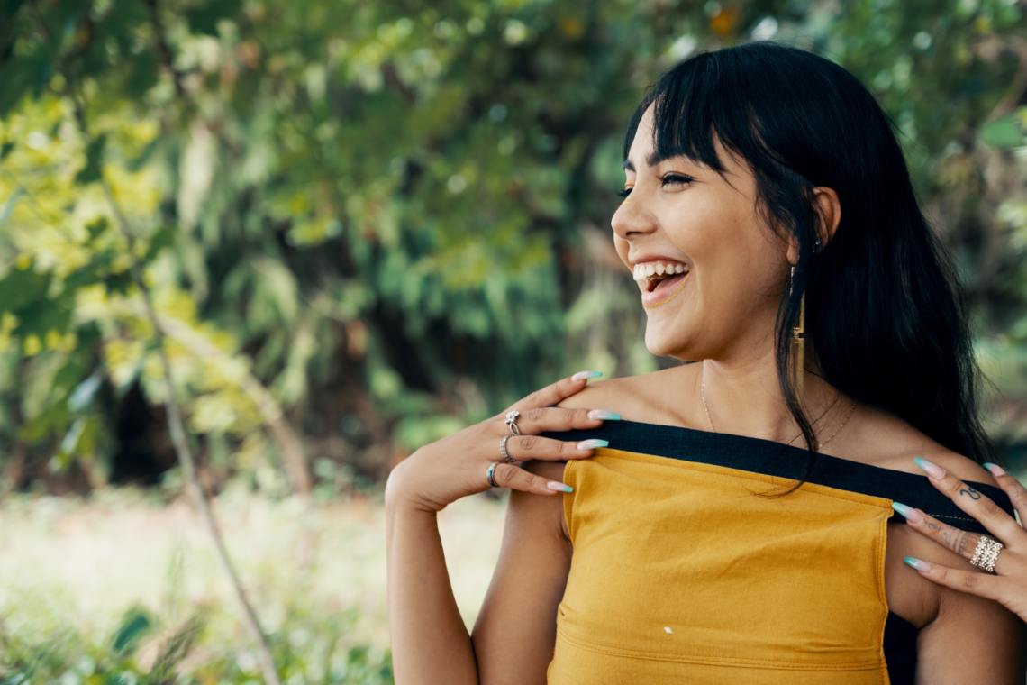Happy indian woman with black hair and a yellow top
